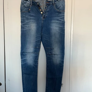 Blå boyfriend jeans  - Snygga blå jeans från Amisu med knappar i gylfen. De har en avslappnad passform och klassisk femficksdesign. Perfekta för en casual look. Finns en liten fläck på baksidan men inget som syns ❤️