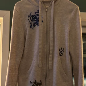 Vitgrå zip-hoodie från Zadig & Voltaire - Säljer en vitgrå zip-hoodie från Zadig & Voltaire med feta tryck. Stl S.