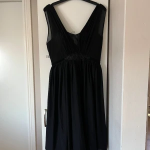 Svart mid klänning från Cream - Elegant svart mid klänning från Cream med v-ringad design och vackra broderade detaljer. 