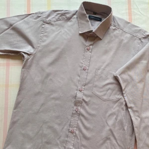 Vintage Tommy hilfinger skjorta - Snygg grå skjorta med klassisk krage och knappar framtill. Skjortan har en bröstficka och är perfekt för en stilren look. Passar bra till både vardag och mer uppklädda tillfällen. Från märket Tommy hilfinger! Perfekt skick & har knappt blivit använd. Pris kan diskuteras!