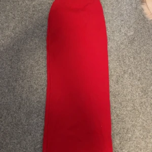 Röd långkjol - Snygg röd långkjol i en klassisk design. Perfekt för att sticka ut med en stark färg. Kjolen har en slits baktill för extra rörelsefrihet.