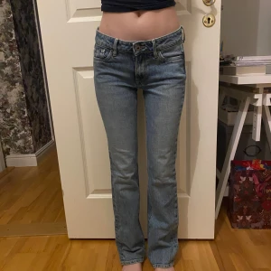 Blå bootcut jeans - Snygga blå bootcut jeans med klassisk femficksdesign och knappgylf. Perfekta för en avslappnad stil. De har en lätt tvättad look som ger en vintage känsla.