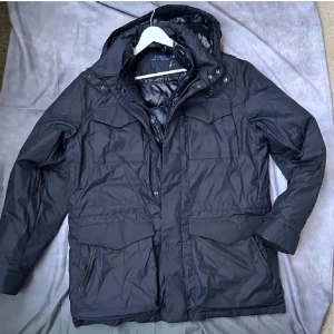 Marinblå FieldJacket från Polo Ralph Lauren - Snygg marinblå Fieldjacket från Polo Ralph Lauren med dragkedja och knappar. Jackan har en quiltad design och praktiska fickor. Då jackan är relativt tunn funkar den perfekt nu på våren! Jackan är helt ny(testad 1 gång) Nypris 6900kr