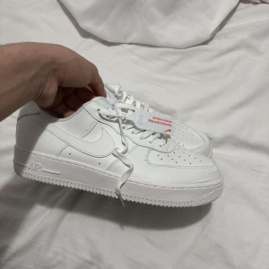 Vita Nike Air Force sneakers - Snygga vita Nike Air Force sneakers med klassisk design och snörning. Perfekta för en stilren look. Tillverkade i skinn med en robust sula för extra komfort. Splitter ny inte använd fel storlek