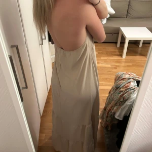 Beige långklänning med öppen rygg - Klänning från Design by si
