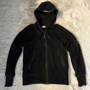 C.P. Company Diagonal Raised Zip - Svart Zip Hoodie från C.P. Company. Storlek: Small. Bra skick. Zippern är lagad syns på sista bilden. 100% äkta