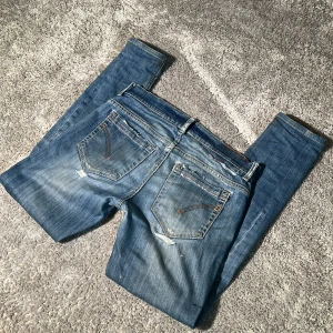 Blå dondups - Snygga blå jeans med slitningar på knäna och en cool tvättad look. Skicket är 5/10 där med de är ganska så slitna men funkar 100% att ha på sig!
