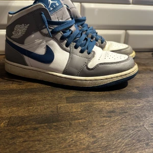 Nike Air Jordans i grått och blått - Snygga Nike Air Jordans i en stilren kombination av grått, blått och vitt. Har använd en del och har lite lite skador inuti och creases på toe boxen . Storlek 43. Ingen låda eller nått sånt finns 