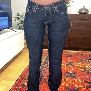 Knappt använda truies  - Snygga mörkblå jeans från True Religion med ikonisk broderad design på bakfickorna. De har en lågmidjad passform och bootcut-stil. Perfekta. Säljer för att de inte passar mig (tjejen i bilden är min syrra). Storlek 28 men hade sagt det är mindre (xs-s)