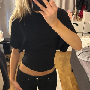 Svart kortärmad topp - Säljer denna populära tshieten från Nelly som har en jätte fin passform! 