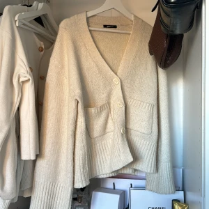 Beige kofta från Gina Tricot - Mysig beige kofta från Gina Tricot i storlek M. Perfekt för kyliga dagar med sina långa ärmar och två praktiska fickor framtill. Koftan har en klassisk design med knappar och ribbade detaljer vid ärmslut och nederkant. Köpt i höstas och bara använt den lite hemma🌸