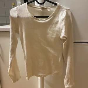 Vit ribbad långärmad tröja - Säljer en stilren vit ribbad tröja med långa ärmar. Tröjan är i bra skick och passar utmärkt till höst- och vårgarderoben. Skön och enkel att matcha med olika outfits!