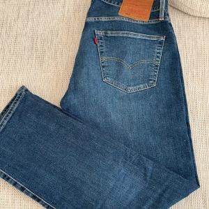 Blå jeans från Levi's - Säljer ett par klassiska blå Levi's jeans i bra skick. Perfekta för vardagsbruk och passar till det mesta. Använda 2 gånger