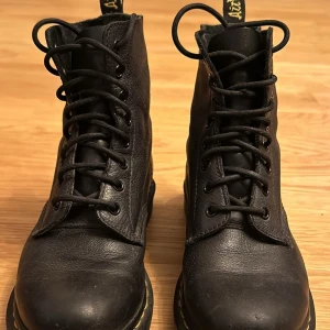 Svarta boots med snörning - Säljer ett par klassiska svarta boots i skinn med snörning. De har en robust design och är perfekta för höst och vinter. Skorna är i bra skick och har en bekväm passform. Perfekta för både vardag och fest!
