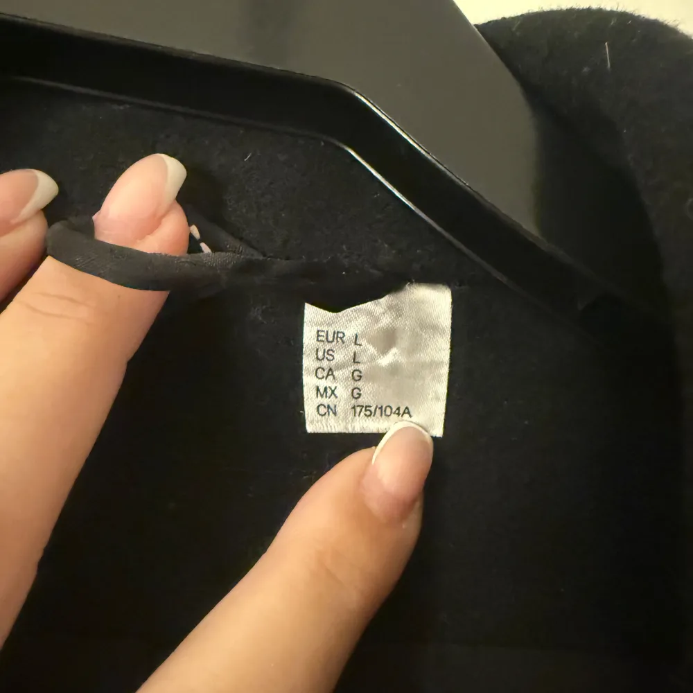 Säljer en elegant svart kappa i storlek L. Den har en klassisk design med knappar framtill och en stilren krage. Perfekt för höst och vinter, och passar både till vardags och fest. Kappan är i mycket bra skick och redo för nya äventyr!. Takit.