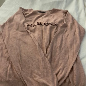 Rosa tröja med volangdetaljer från Mango - Säljer en superfin rosa tröja från Mango med volangdetaljer vid halsen. Perfekt för både vardag och fest! Tröjan är i bra skick och har en mjuk och bekväm passform. Passar perfekt till höst och vår.