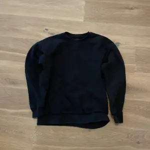 Säljer en stilren svart sweatshirt i mycket bra skick. Den har en klassisk rund hals och långa ärmar, perfekt för både vardag och chill. Materialet känns mjukt och bekvämt, vilket gör den idealisk för höst och vinter. Passar till det mesta i garderoben!