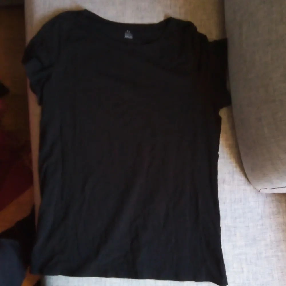 Säljer en svart t-shirt från KappAhl i storlek XL. Den är gjord av ekologisk bomull och är supermjuk och bekväm. Perfekt för vardagsbruk eller att ha under en snygg jacka. T-shirten har en klassisk passform och korta ärmar. Ett måste i basgarderoben!. T-shirts.