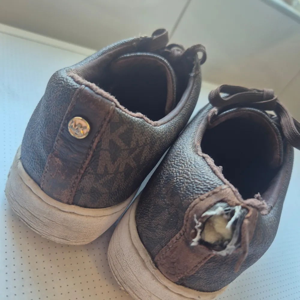 Säljer ett par bruna sneakers från Michael Kors i begagnat skick , dock så har ena märket lossnat på baksidan man kan säkert sy ihop från skräddare. Nypris 1600 säljer dom för 300. Skor.