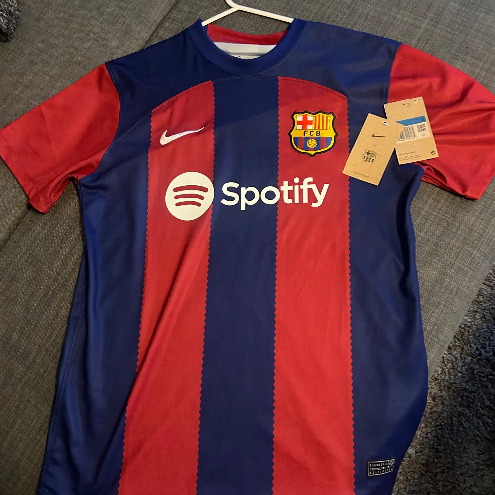 Säljer en ny FC Barcelona fotbollströja i rött och blått med klubbens emblem och Spotify-logga på framsidan. Tröjan är kortärmad och i randigt mönster. Perfekt för alla Barça-fans! 🏆Storlek s/m. T-shirts.