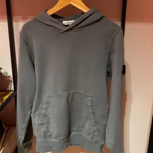 Säljer en snygg grå hoodie från Stone Island. Perfekt för både höst och vår, och den är i bra skick. Passar till det mesta och är superbekväm! Storlek S passar 175 