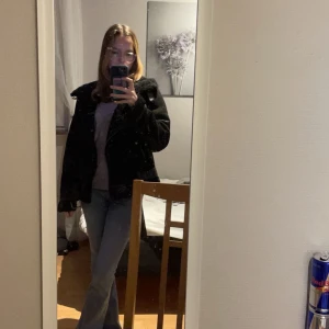 Svart jacka med bälte - Säljer en snygg svart jacka med bälte och dragkedja. Perfekt för höst och vinter. Jackan har en cool och modern stil som passar till både vardag och fest. Den är i bra skick och ger en edgy look till vilken outfit som helst.
