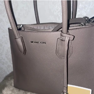 Brun axelväska från Michael Kors - Säljer en snygg brun axelväska från Michael Kors i mycket bra skick. Väskan är gjord av skinn och har en praktisk dragkedja upptill👜✨