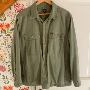 Overshirt från Lee - Säljer en snygg grön overshirt från Lee i storlek M. Perfekt för vår och höst, och funkar både som jacka och skjorta. Passar till det mesta i garderoben!