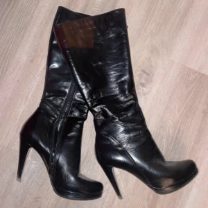 Svarta stövletter med klack - Snygga svarta stövletter i skinn med hög klack och spetsig tå. Perfekta för en utekväll eller fest. De har en dragkedja på sidan för enkel på- och avtagning. I storlek 40 men funkar för både 39 och 40. Passar bra till både jeans och klänning. Ett måste för garderoben!