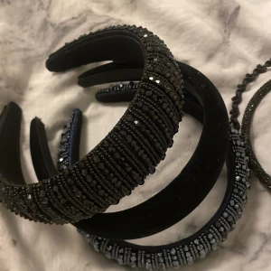 Svarta och glittriga diadem - Säljer ett set med flera svarta diadem, några med glittriga detaljer och pärlor. Perfekt för att piffa upp vilken outfit som helst! De är i bra skick och passar för både vardag och fest. 🖤✨