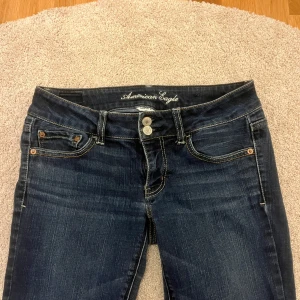 bootcut jeans American Eagle - De har en låg midja och dubbla knappar i gylfen. Köpte secondhand men passade inte och därför säljer jag vidare. Short length!! Innerbenslängden är ca 72cm