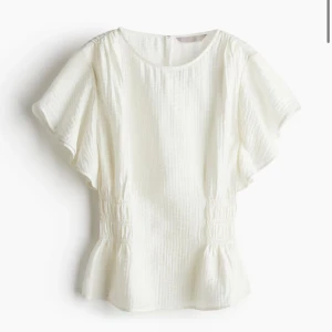 Vit blus med volangdetaljer - Pris går att diskutera!!!!  Säljer en söt vit blus med korta ärmar och volangdetaljer i nederkant. Perfekt för både vardag och festliga tillfällen. Blusen har en lös passform och är gjord i ett lätt och luftigt material. Superfin💞💞💞💞