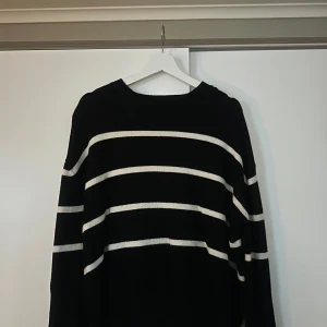 Svart och vit randig tröja - Säljer denna otroligt mjuka och sköna stickade tröja från Bikbok. Bra skick då den inte är använd så mycket!