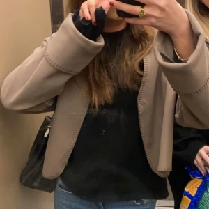 Beige jacka  - Säljer en stilren beige jacka i mycket bra skick. Den har en elegant och enkel design med långa ärmar och en öppen front. Perfekt för både vardag och festliga tillfällen. Passar bra till jeans eller klänning för en chic look.