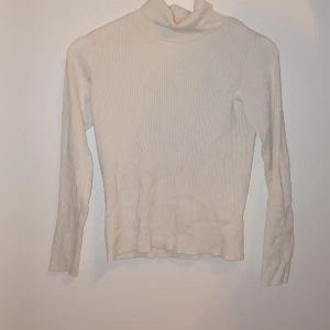 Vit ribbad polotröja - Säljer en stilren vit ribbad polotröja i mycket bra skick. Perfekt för höst och vinter med sin mysiga och varma design. Tröjan har långa ärmar och en klassisk polokrage som håller dig varm. Passar både till vardags och lite finare tillfällen. 🧣✨