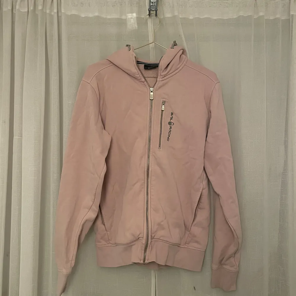 Säljer en superfin rosa hoodie från Sail Racing i storlek M. Den har en dragkedja framtill och en mysig huva. Inga rejäla skador.. Tröjor & Koftor.