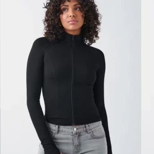 Soft touch zip - Snygg svart zip med dragkedja framtill. Perfekt för både vardag och träning. Den har en tight passform. Är använd 1 gång. Skriv för frågor eller bilder💞 nypris:359kr