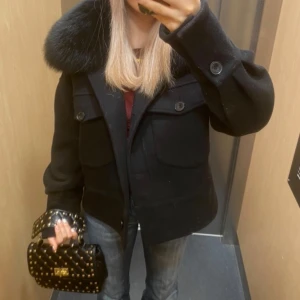 Svart kappa med pälskrage - Säljer min populära meotine kort kappa jacka med en lyxig pälskrage. Storlek xs/ s perfekt för höst och vinter. Den är i mycket bra skick och ger en stilren look. Endast använt i en termin 