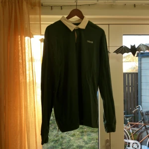 Grön långärmad pikétröja från Vans - Säljer en snygg grön långärmad pikétröja från Vans. Den har en vit krage och knappar framtill. Perfekt för en avslappnad stil eller en dag på stan. Tröjan är i bra skick och redo för nya äventyr! Storlek Large. Sparsamt använd.