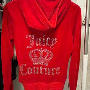  supermjuk och snygg röd velourjacka från Juicy Couture. Den har en stor Juicy Couture-logga med strass på ryggen. Använd ett par gånger men det syns ej. Storlek L men passar även M eftersom den är väldigt liten i storleken