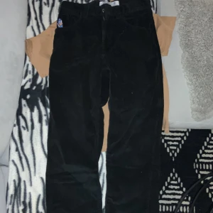 Svarta manchesterbyxor från 93! Cords - Säljer ett par svarta manchesterbyxor från 93! Cords. De har en cool broderad detalj på fickan och en gul etikett med logga baktill. Perfekta för höst och vinter med sin mjuka och varma känsla. Byxorna har en normal passform och är i mycket bra skick.