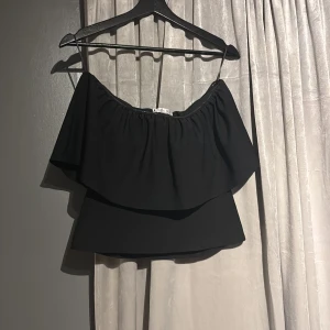 Svart offshoulder topp från Zara - Snygg svart offshoulder topp från Zara. Köpte denna i sommars och är endast använd 1 gång! M men passar S! Kan diskutera pris privat