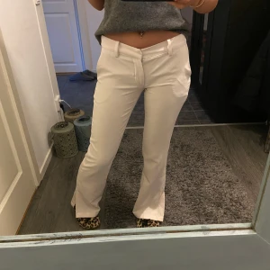 Vita lågmidjade kostymbyxor - Vita lågmidjade kostymbyxor med slits nedtill, använda kanske 5 gånger.😊  Storlek 34