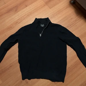 Svart tröja med dragkedja - Säljer en stilren svart tröja med dragkedja i kragen från hm. Perfekt för både vardag och lite finare tillfällen. Tröjan har långa ärmar och är i ett mjukt material som känns skönt mot huden. Passar bra till höst och vinter. Hör av dig vid intresse!