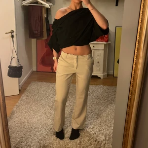 Beige kostymbyxor  - Säljer ett par stilrena beige kostymbyxor. De är Midwaist med en rak passform och har en klassisk design med dragkedja och knapp framtill. Perfekta för både vardag och fest! 🕺