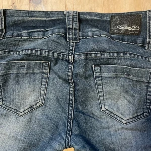 Blå jeans från Two Days Later - Säljer ett par snygga blå jeans från Two Days Later. De har en bootcut-stil och är lågmidjade med knappar fram. Jeansen är i bra skick och har en klassisk tvättad look. Dom är mellan storlek S/M, och passar perfekt i längden på mig som är 160cm lång💓💓. 