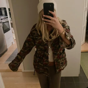 Camouflagejacka med knappar - Säljer en cool camouflagejacka med knappar framtill. Perfekt för höst och vår, med en avslappnad passform. Jackan har långa ärmar och är i mycket bra skick. 