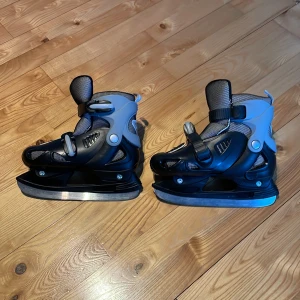 Svarta och grå justerbara skridskor 34-37 - Säljer ett par svarta och grå justerbara skridskor. De är utrustade med spännen för enkel justering. Storlek 34-37. Perfekta för vinterns isäventyr!