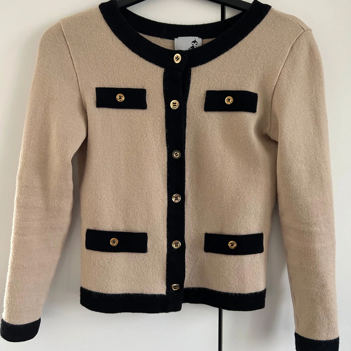 Beige kofta med svarta detaljer