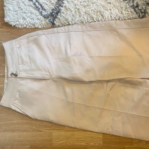 Champagnefärjade finbyxor  - Snygga byxor med två knappar framtill och praktiska fickor både fram och bak. Går att ha både till vardags eller om man exempelvis ska ut. (Färgen syns bäst på sista bilden) 